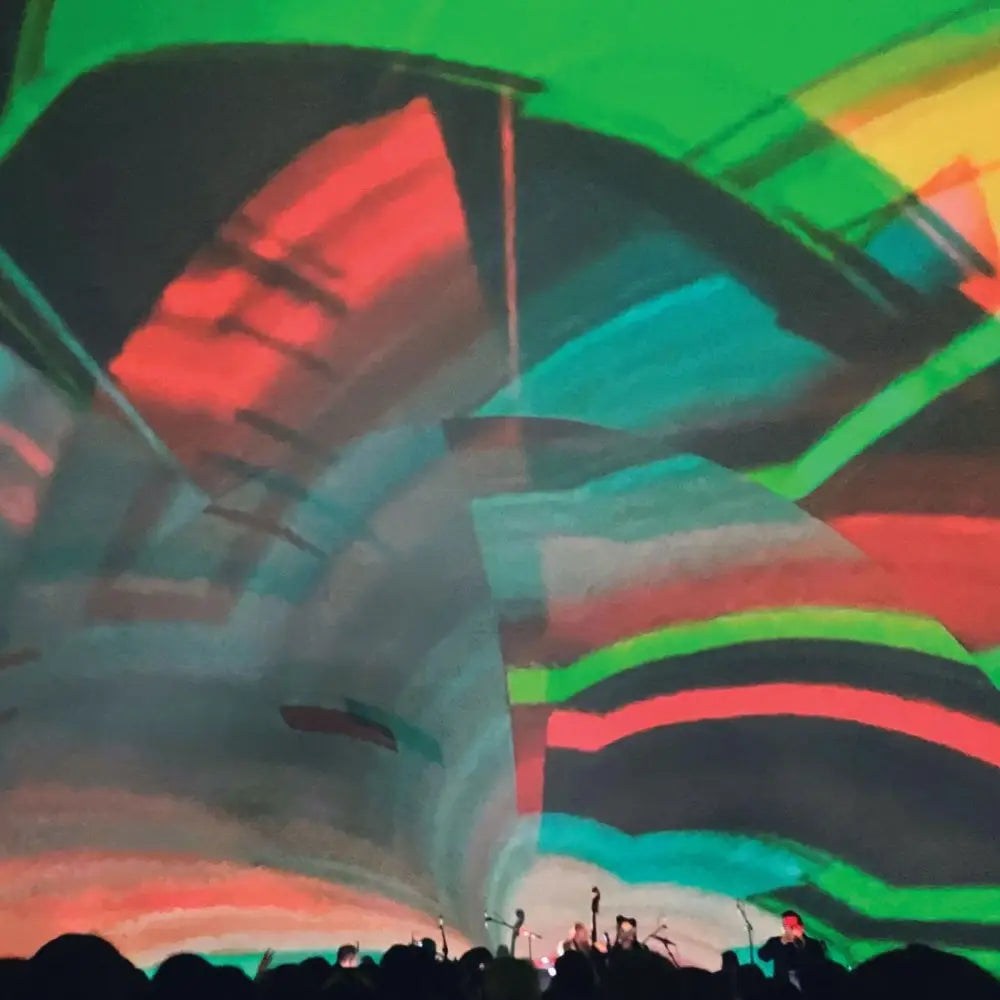 A vibrant, abstract light projection on a curved surface, with a crowd of people in silhouette at the bottom.