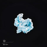 A crumpled, textured blue and white fabric-like object against a black background.